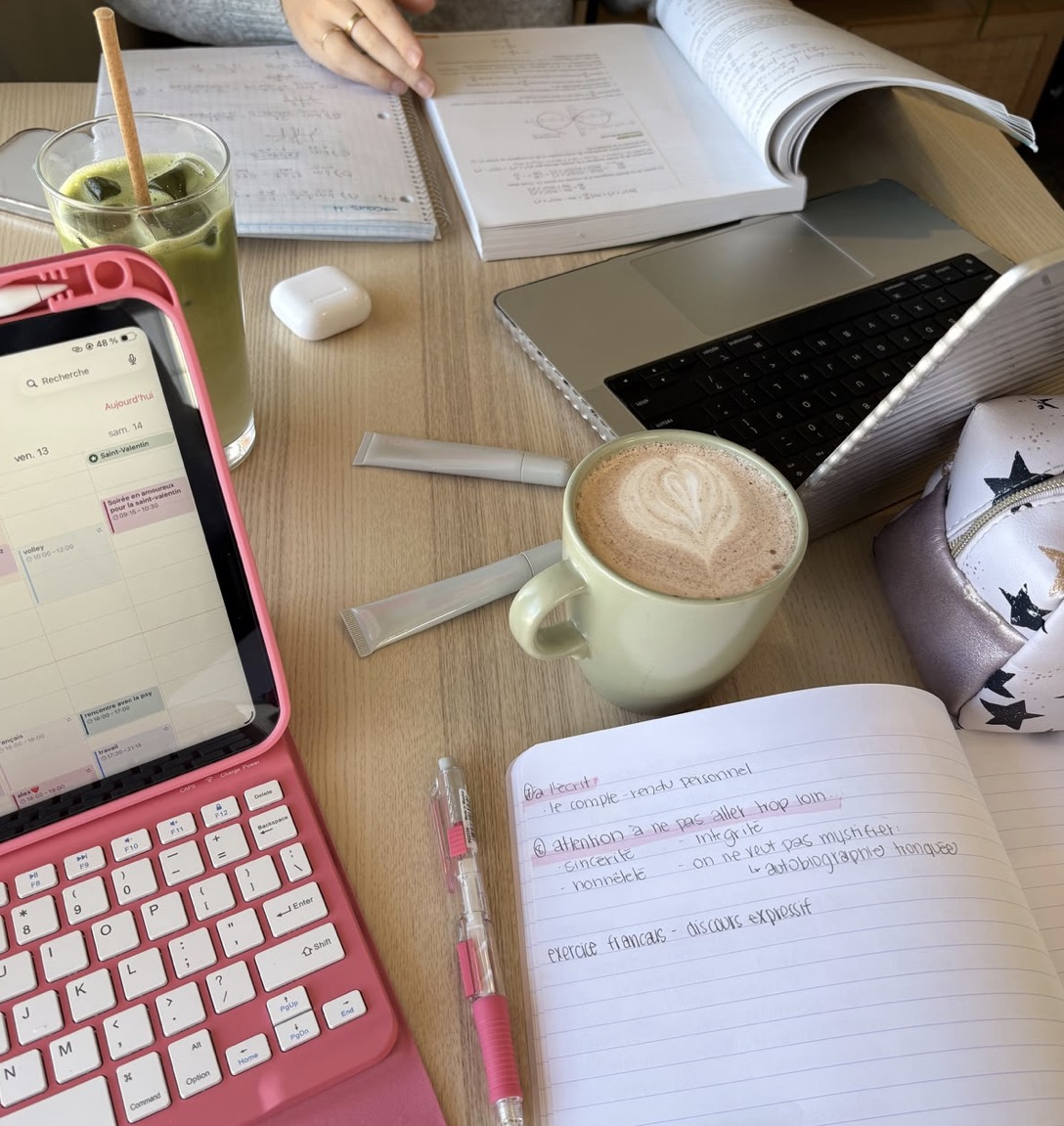 Mesa de estudos com computador, cadernos e café